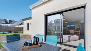 Une terrasse extérieure avec une table, des chaises et un plateau de service pour le café.