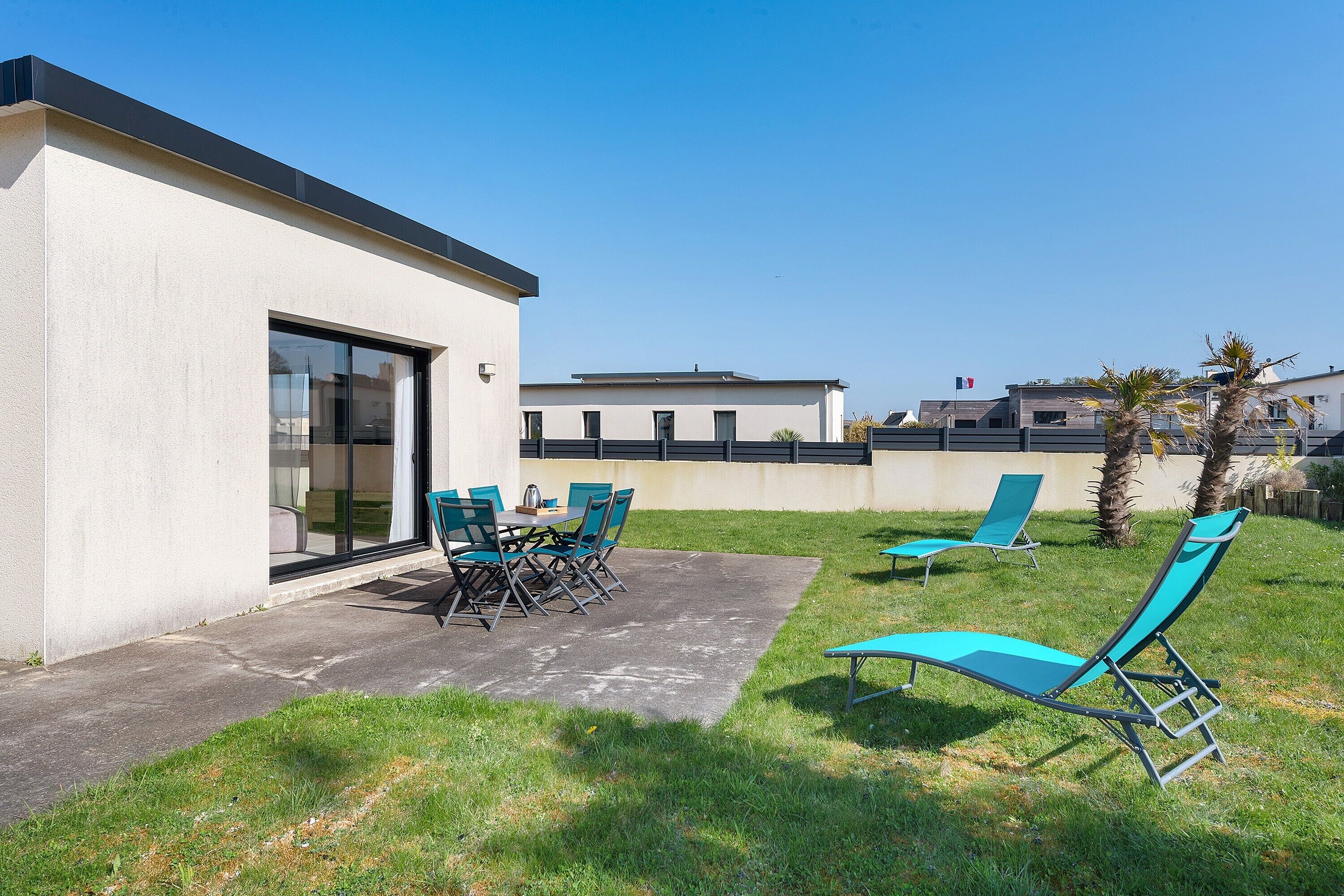 Un bâtiment moderne doté d’un patio aménagé avec du mobilier d’extérieur et offrant une vue sur un ciel dégagé.