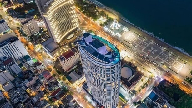 A high-rise hotel with a rooftop terrace, located near a waterfront. - Homie Panorama Beachfront Residences Nha Trang (Nha Trang)