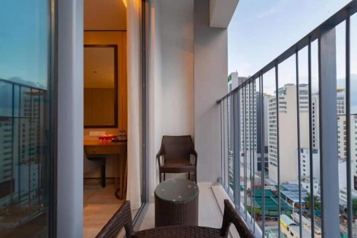 Ein Balkon mit Blick auf die Stadt, ein kleiner Tisch und zwei Stühle.