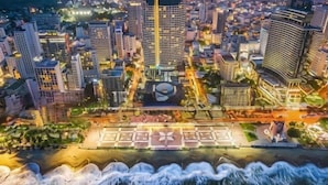 An aerial view of a cityscape with high-rise buildings, a waterfront promenade, and a central plaza. - Homie Panorama Beachfront Residences Nha Trang (Nha Trang)
