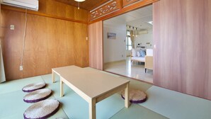 A traditional Japanese room with tatami flooring, a wooden table, and sliding doors. - ITOMAN IN (Itoman)