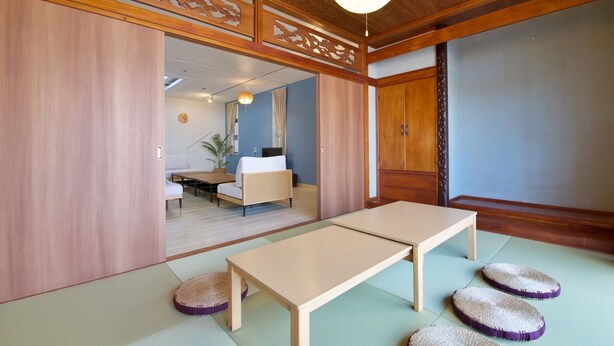A traditional Japanese room with tatami flooring, a low wooden table, and a sliding door. - ITOMAN IN (Itoman)