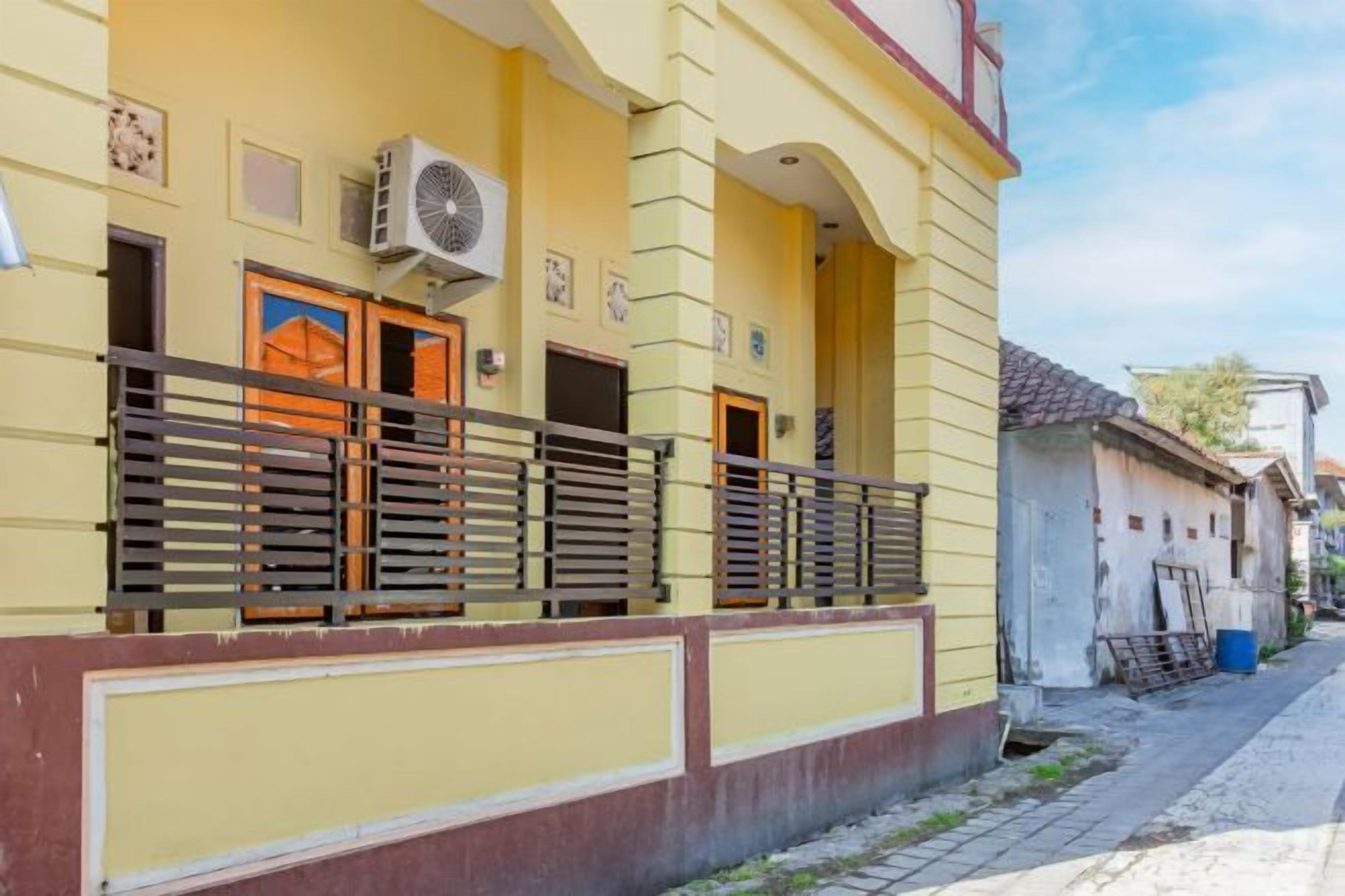 Ein gelbes Gebäude mit Balkon, Tür und Fenster.