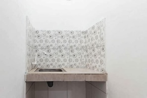 A bathroom with patterned tiles, a sink, and a drain.