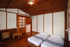 Een traditionele Japanse kamer met tatami vloeren, een laag houten plafond en een schuifdeur.