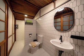 A bathroom with a toilet, sink, and mirror.
