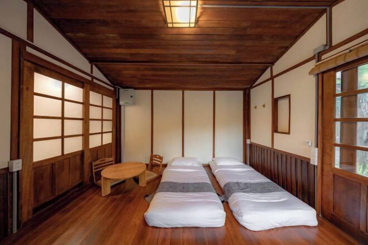 A traditional Japanese-style room with wooden floors, tatami mats, and sliding doors.
