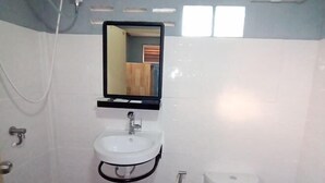 A bathroom with a white sink, a mirror, and a toilet. - ID Garden Home (Lampang)