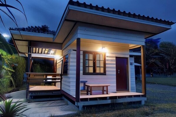 A two-story house with a porch, a dining table, and a bench. - ID Garden Home (Lampang)