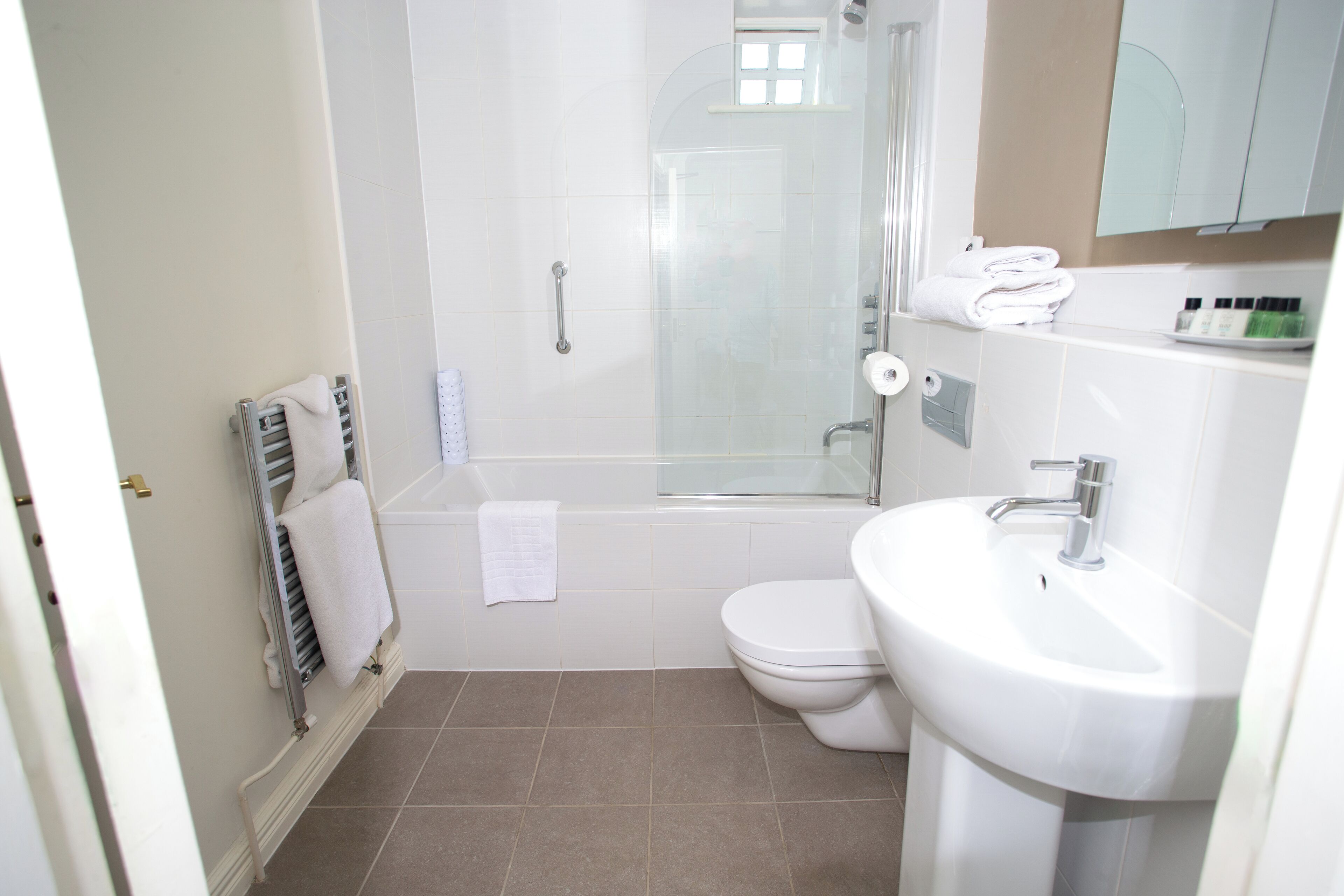 A bathroom with a shower, toilet, and sink.