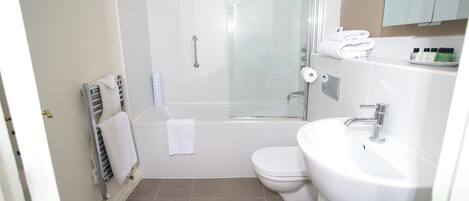 A bathroom with a shower, toilet, and sink.