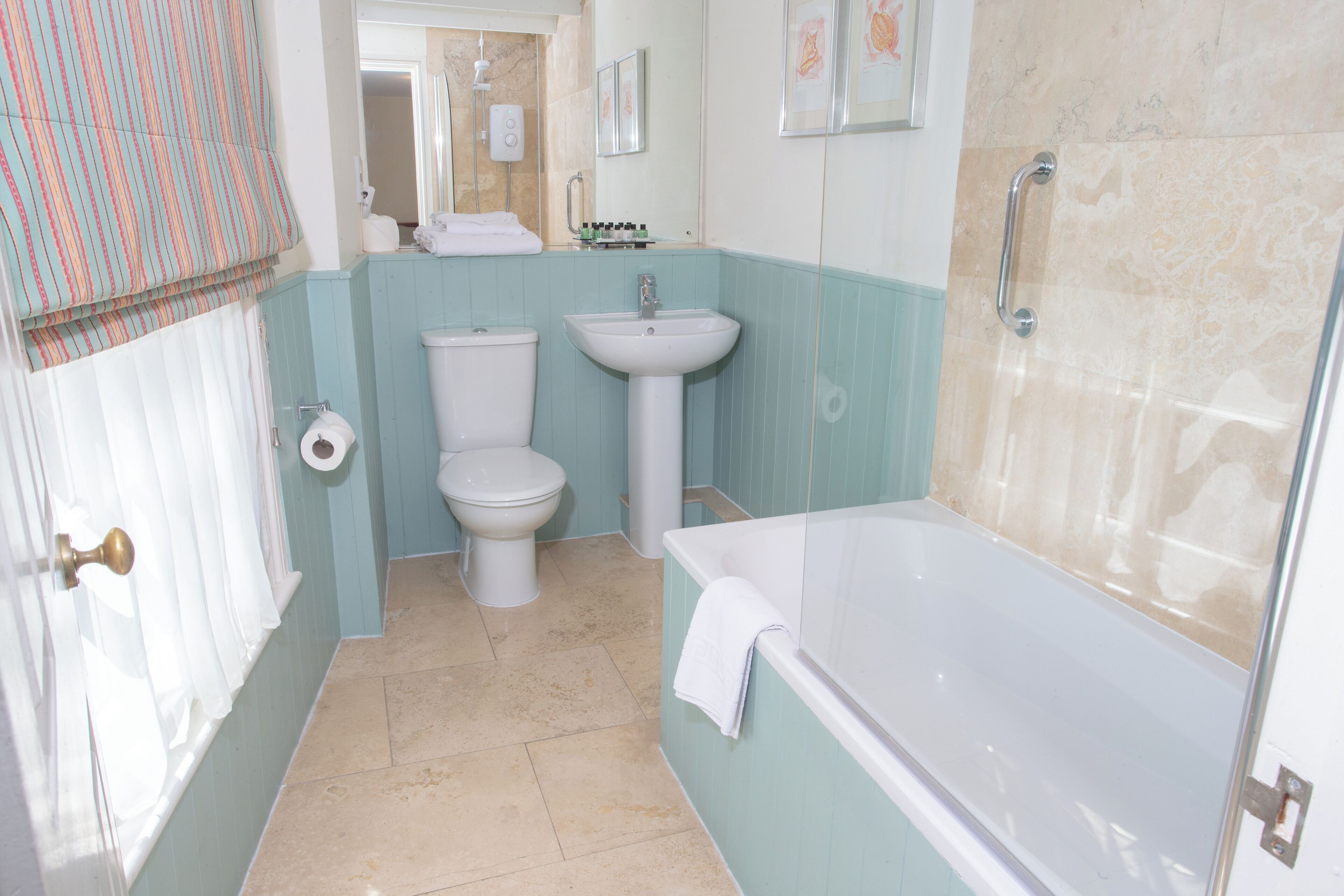 Een badkamer met toilet, wastafel en bad.