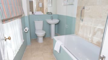 Een badkamer met toilet, wastafel en bad.