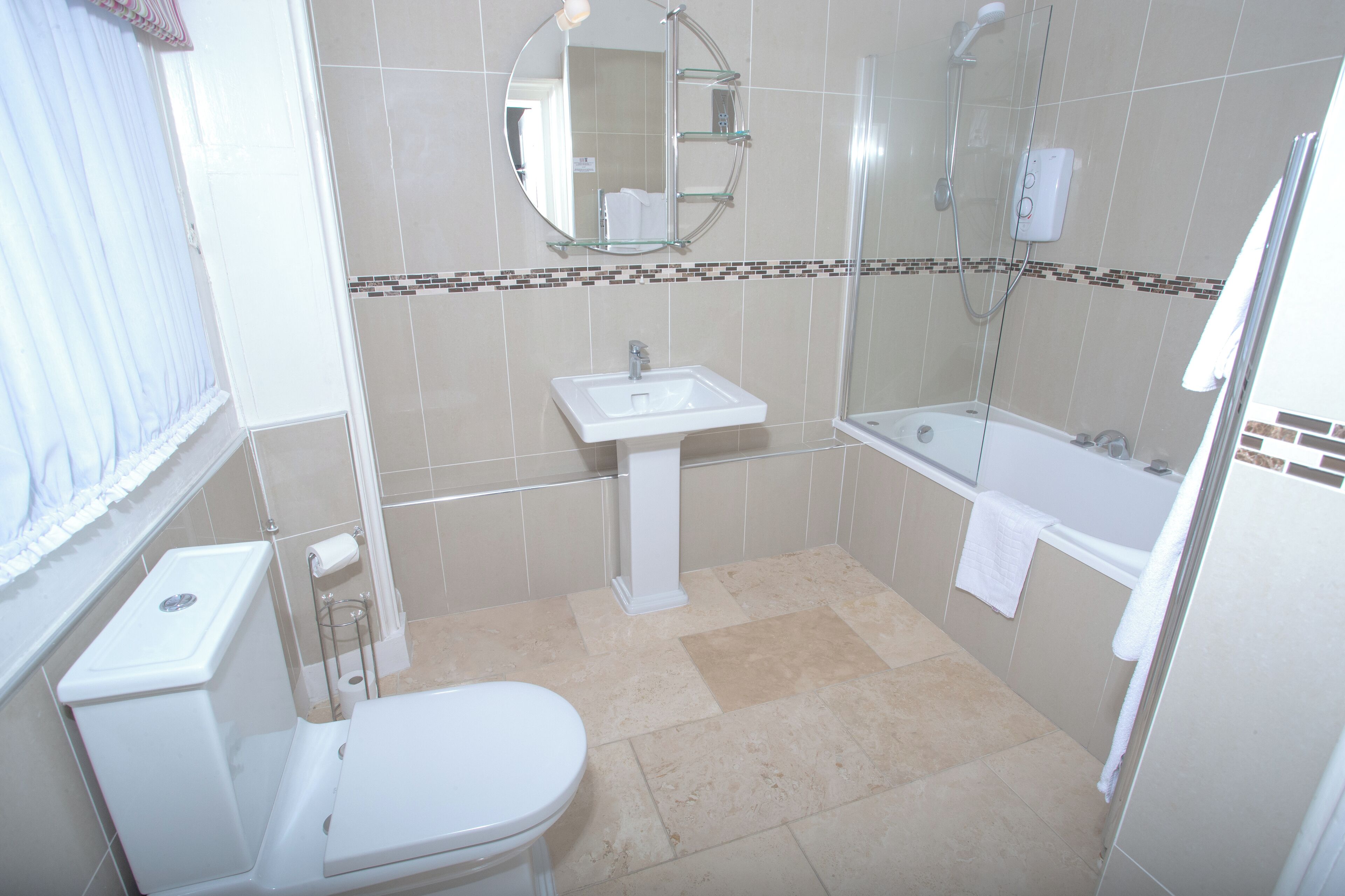 A bathroom with a toilet, sink, and bathtub.