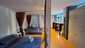 Habitación de hotel con dos camas, un escritorio y un armario.