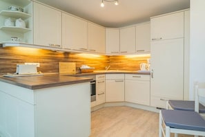 Un four, surface de cuisson, lave-vaisselle, cafetière-théière