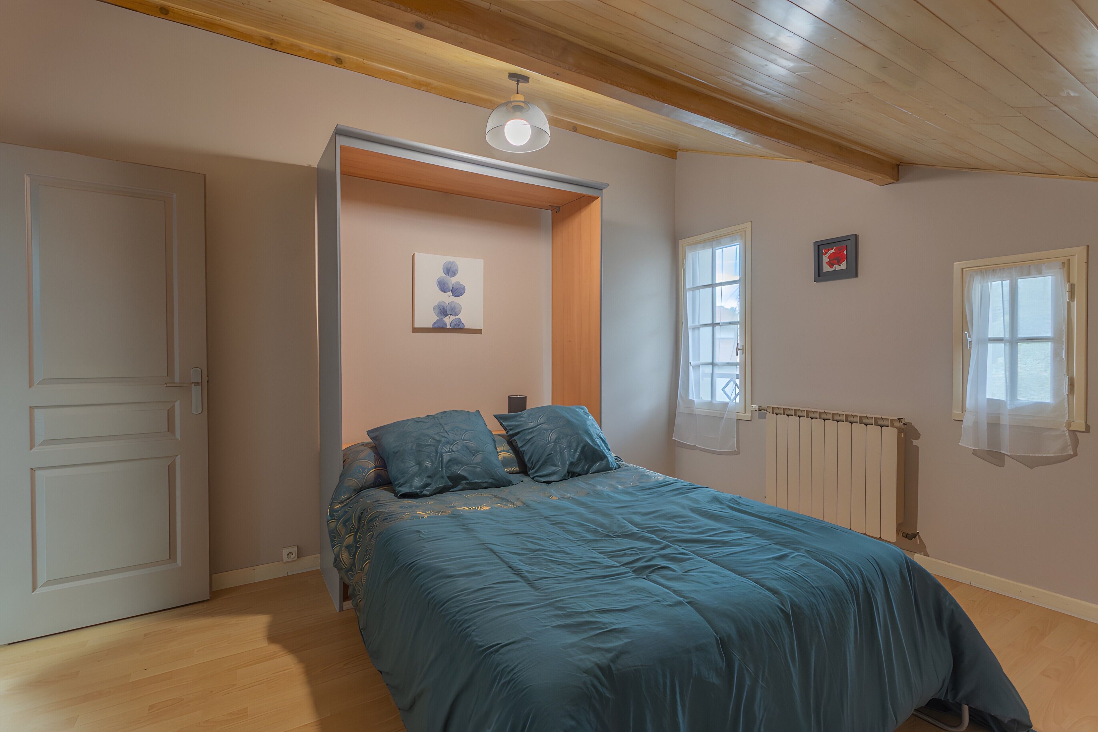 Quarto com cama, porta, radiador e janela.