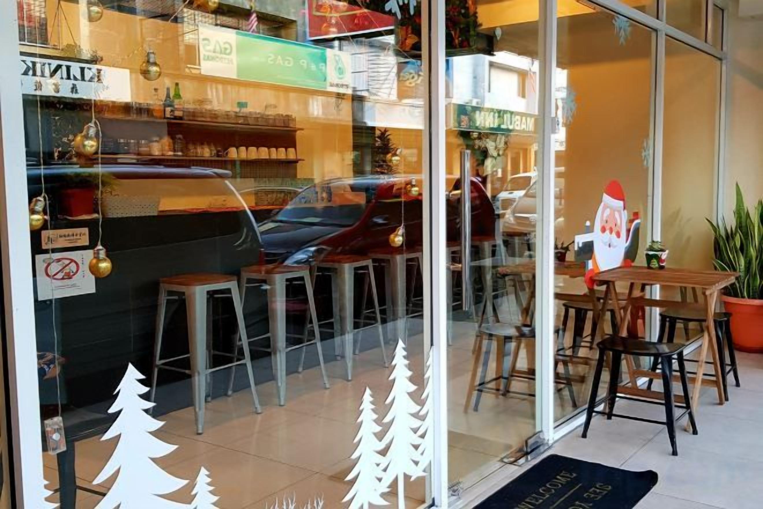 Un restaurant amb gran finestra, terrassa exterior i decoració de nadal.