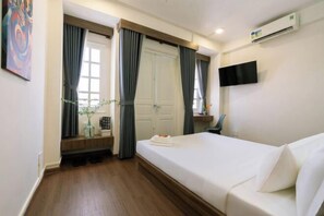 A hotel room with a bed, a TV mounted on the wall, a window with curtains, and a door. - Signy House Hotel Sai Gon Center - Nguyen Binh Khiem (Ho Chi Minh City)