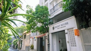 A street view of a building with a sign for 'Signy House Hotel & Apartments'. - Signy House Sai Gon Center - Nguyen Binh Khiem (Ho Chi Minh City)