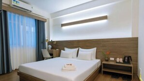 A hotel room with a large bed, bedside table, and a desk with a chair. - Signy House Sai Gon Center - Nguyen Binh Khiem (Ho Chi Minh City)