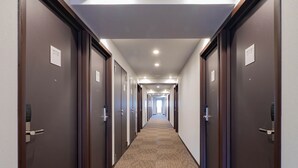 A hotel hallway with doors numbered 516 and 515, carpeted flooring, and recessed ceiling lights. - Toyoko Inn Tokorozawa-eki Nishi-guchi (Tokorozawa)