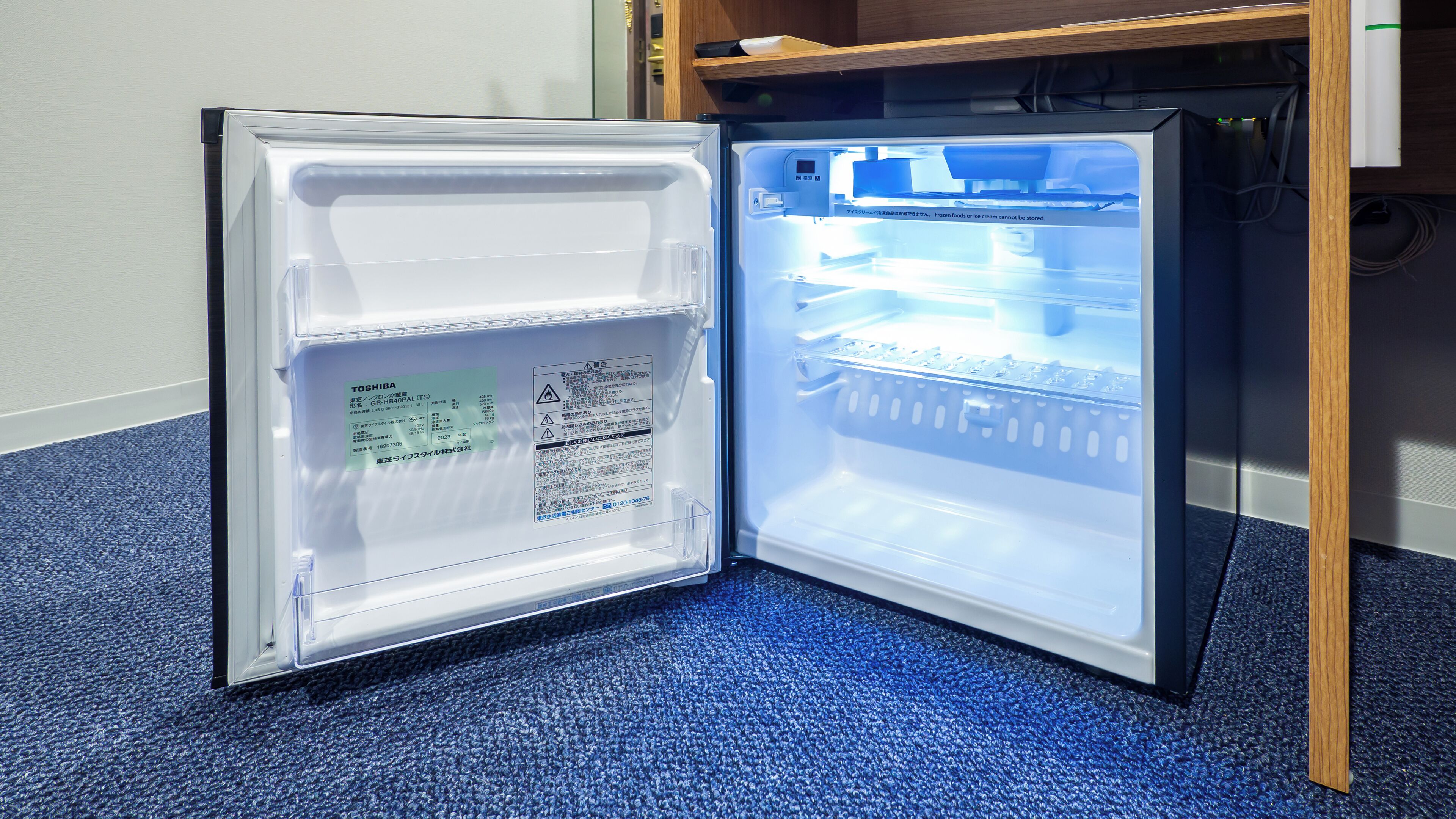 An open refrigerator with a label and a warning message.