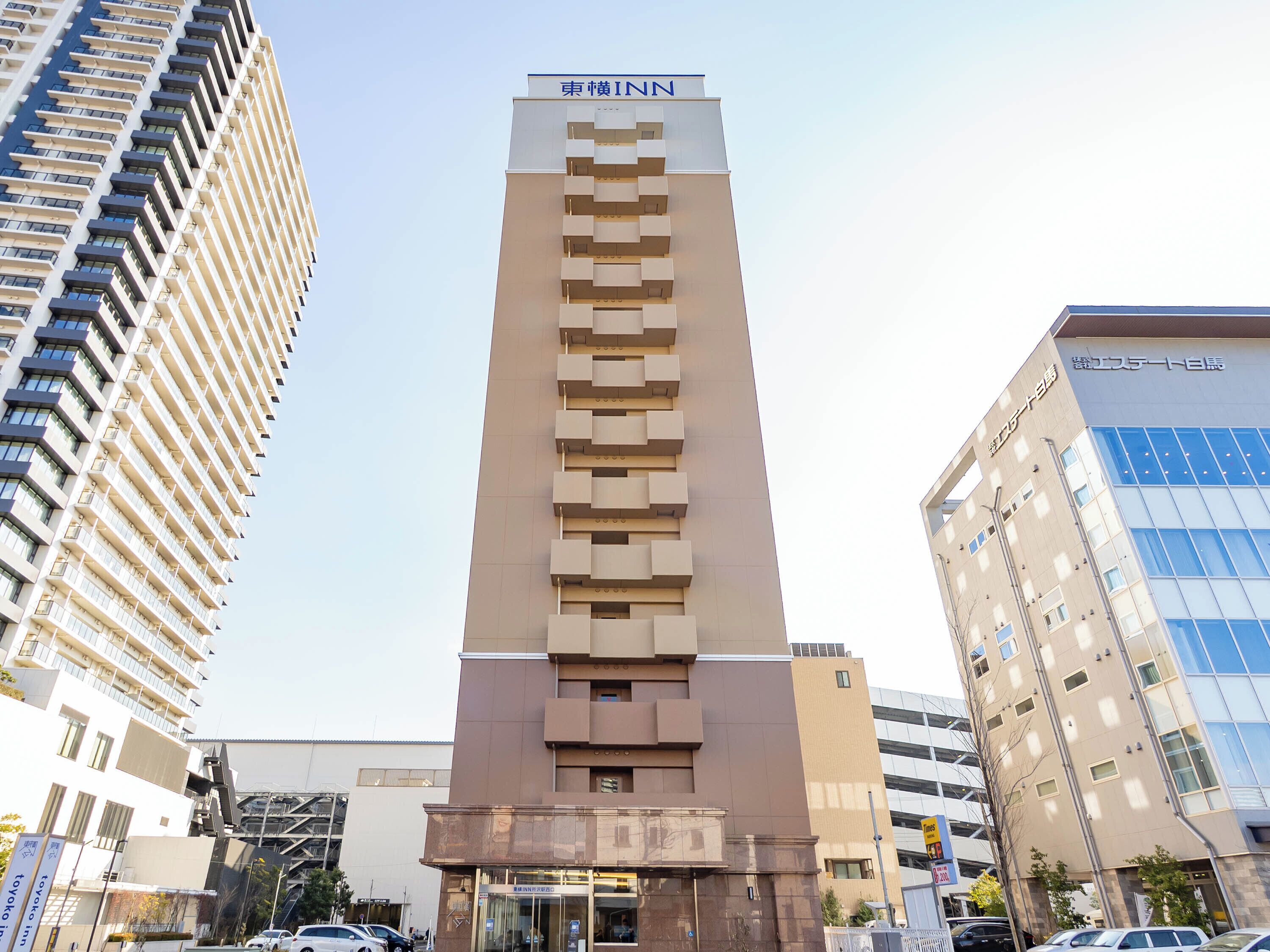 Ein hohes Hotelgebäude mit modernem Design, das eine markante Eingangshalle und einen klaren Himmel im Hintergrund zeigt.