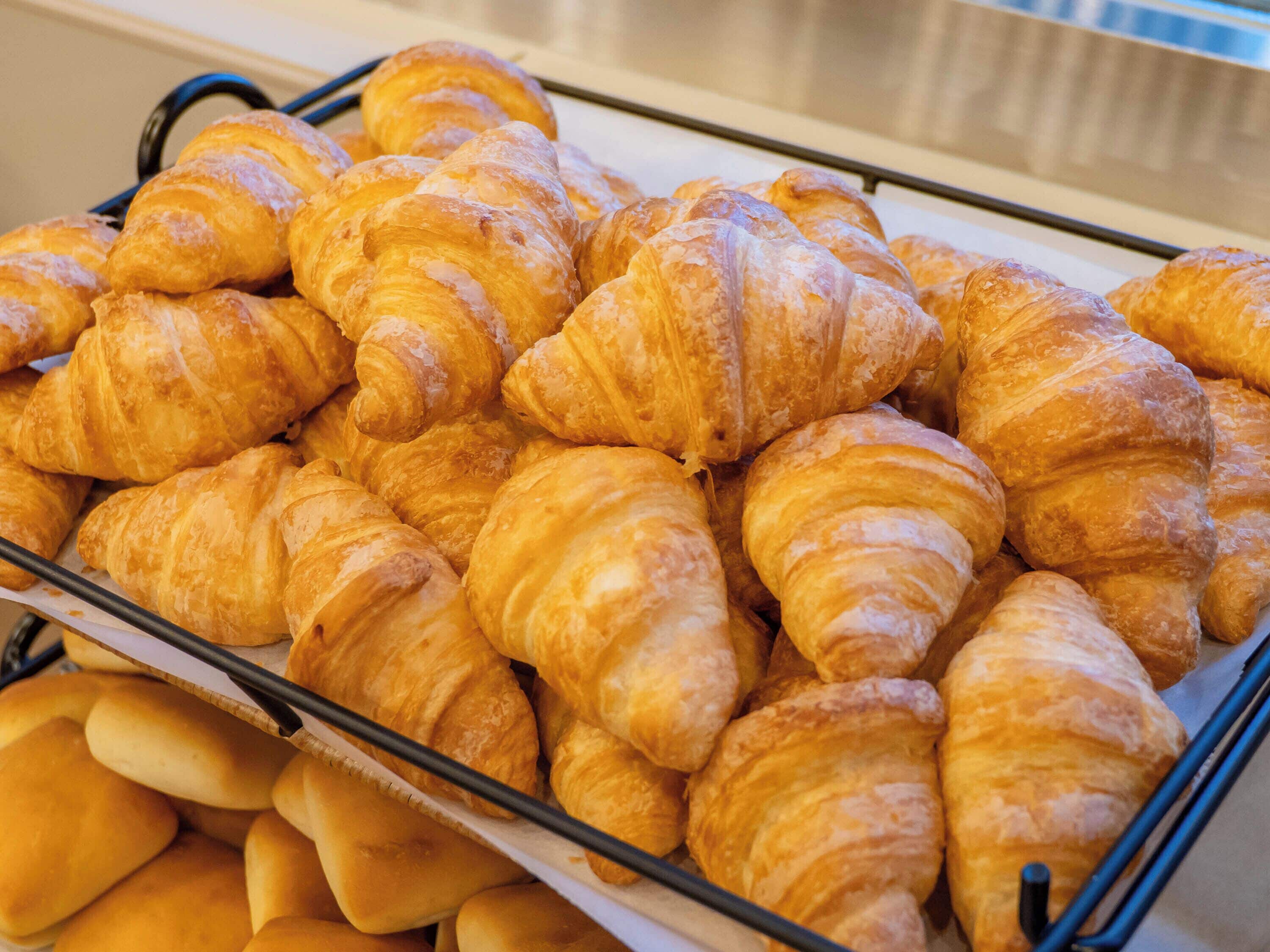 Una bandeja con varios pasteles, incluyendo croissants y otras preparaciones horneadas.