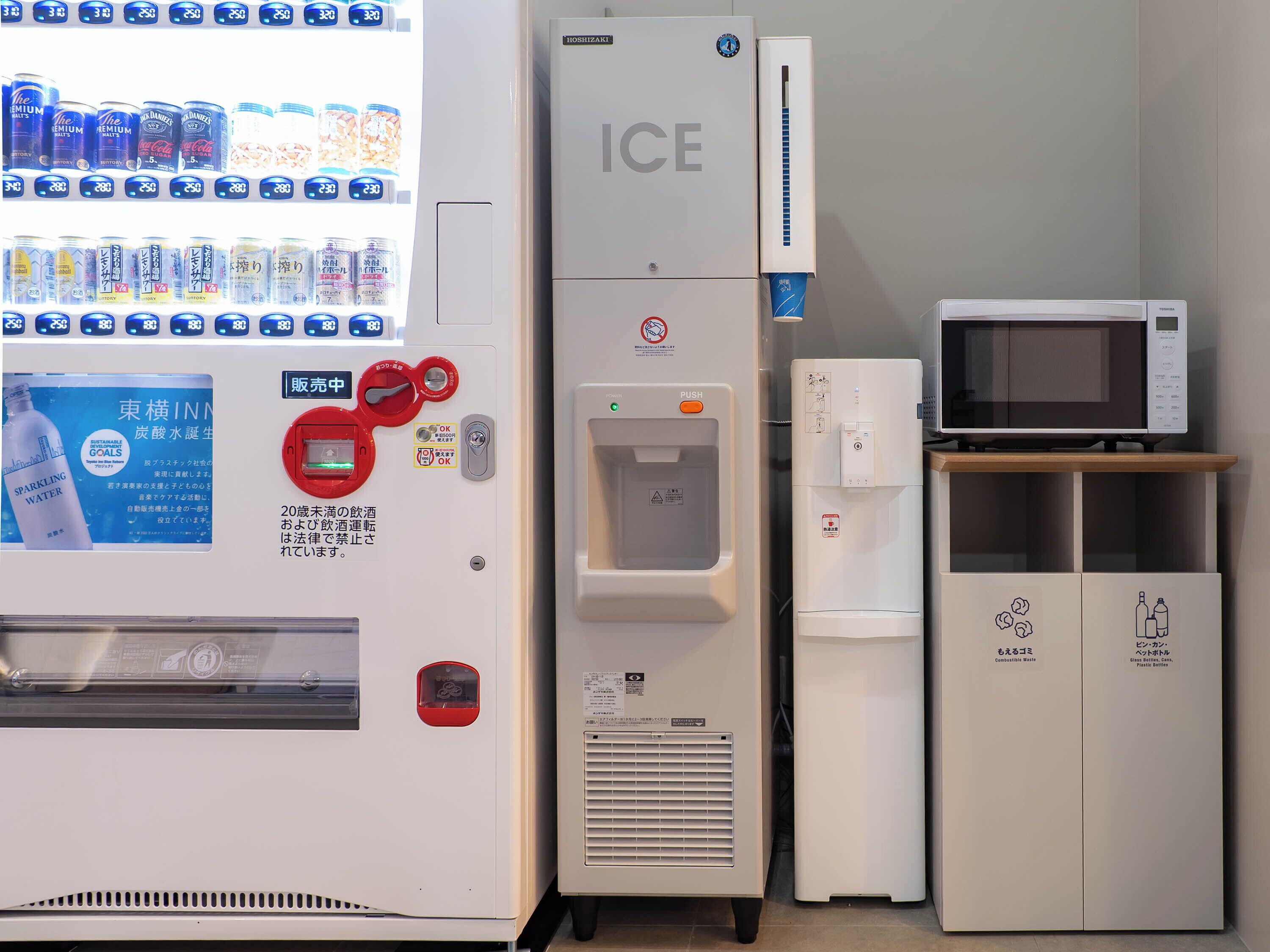 A vending machine with beverages, an ice dispenser, a microwave, and a water dispenser.