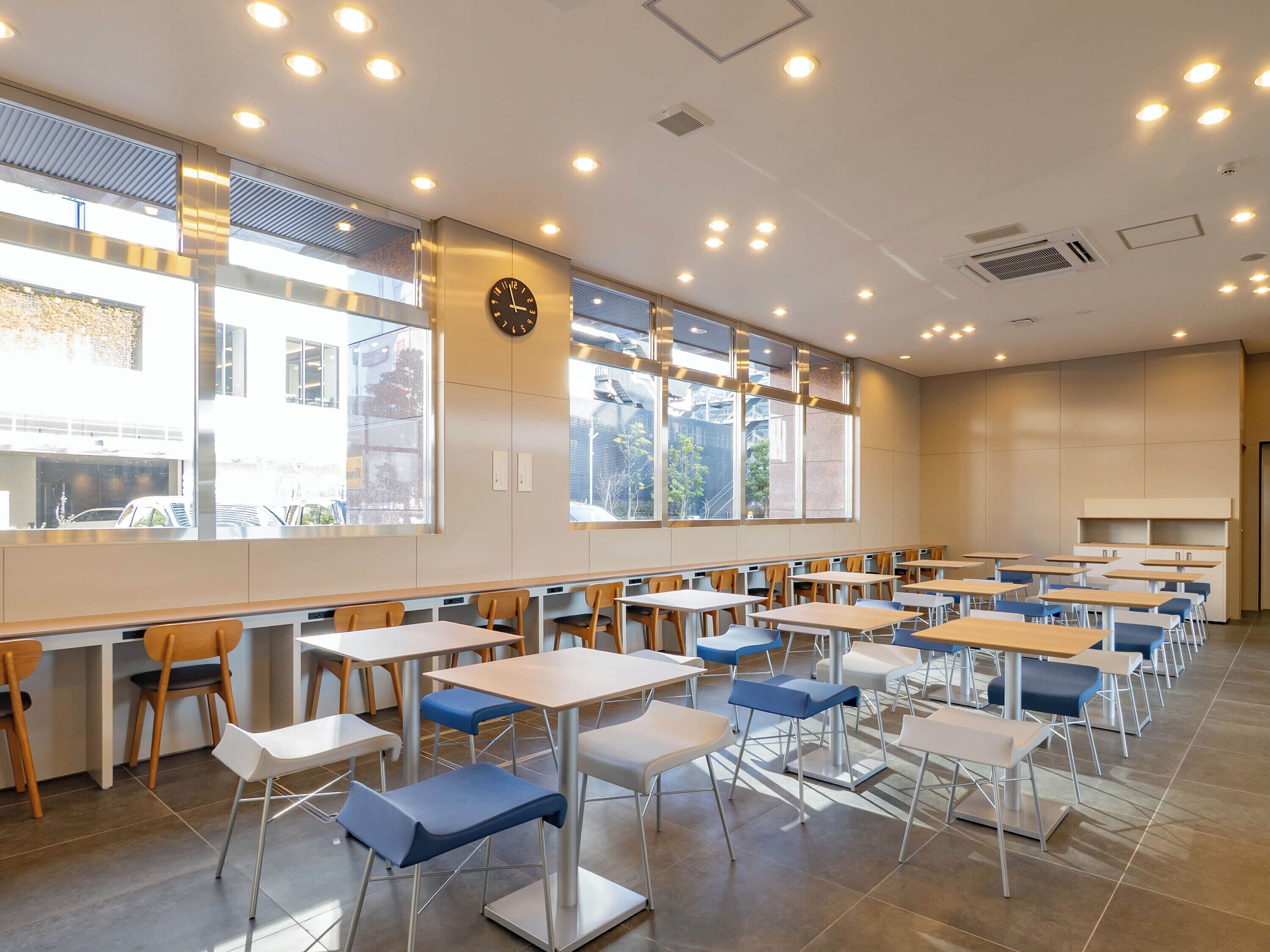 A modern classroom with rows of desks, chairs, and a clock on the wall.