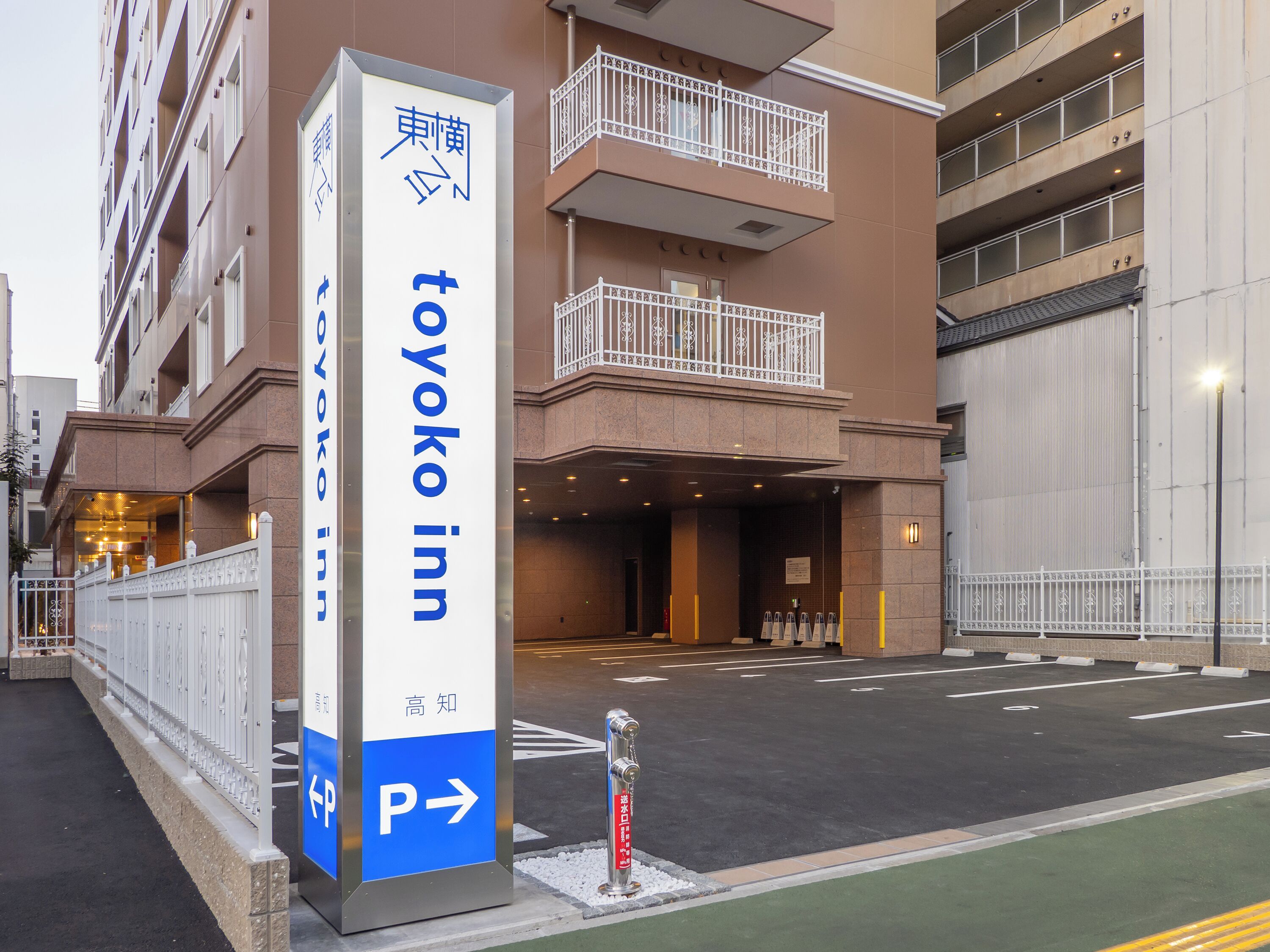 A building with a sign for 'Toyoko Inn' indicating a parking area.