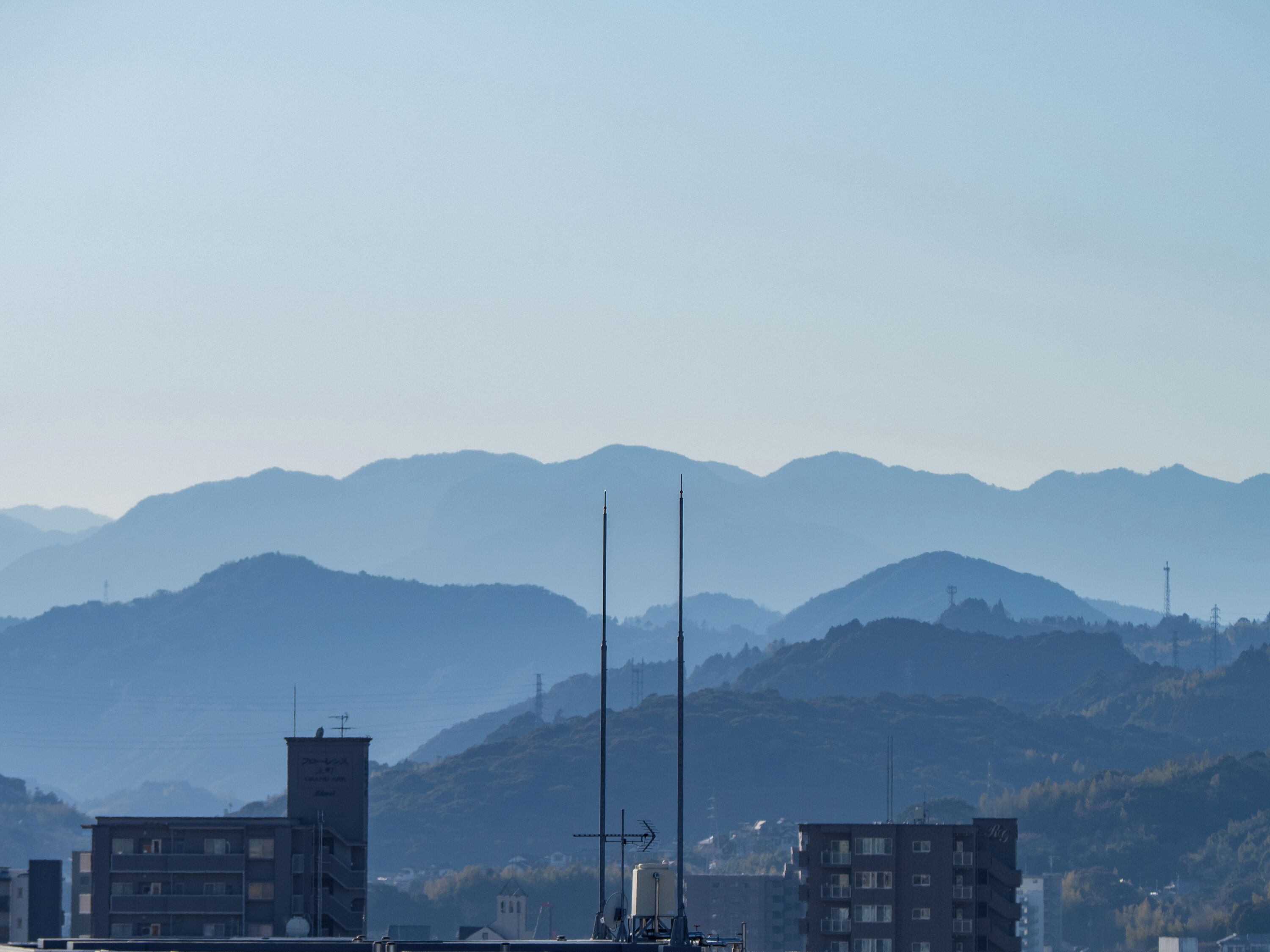 A cityscape with buildings and mountains in the background.