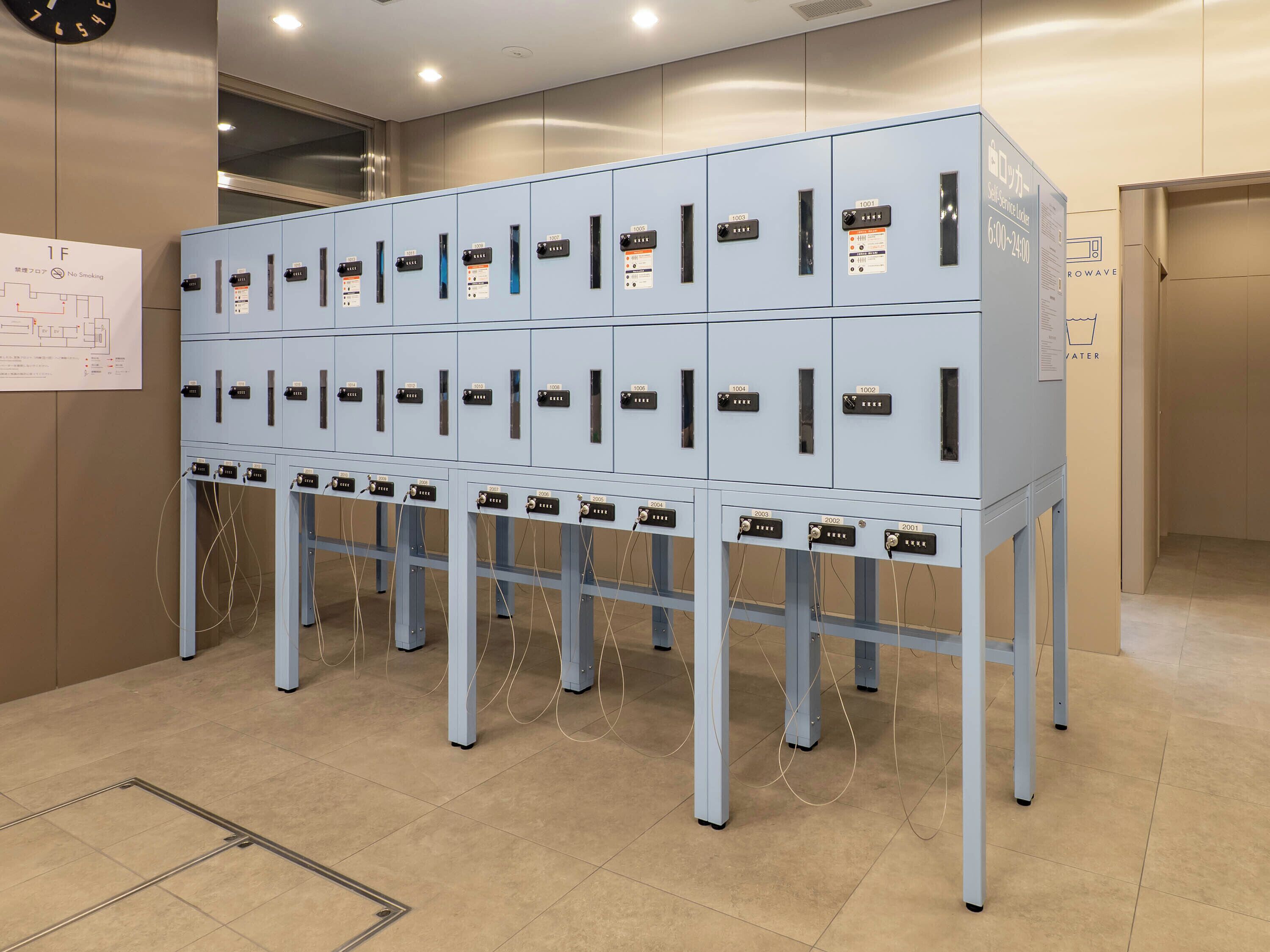 A row of light blue lockers with numbered labels, a clock on the wall, and a map on the left.