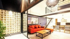 Un salon moderne avec un canapé, une table basse et un escalier menant à un niveau supérieur.