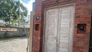 Un edificio de ladrillo con una puerta de madera doble, un letrero que dice