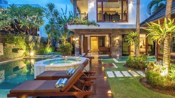 Une maison moderne à deux étages, dotée d’un jacuzzi, d’une piscine et d’un jardin bien entretenu.