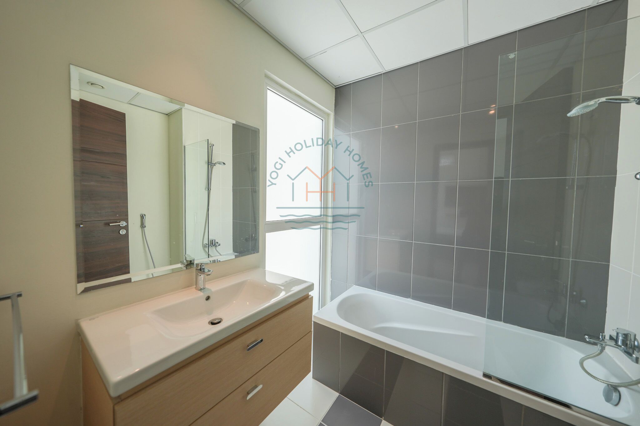 Un bagno moderno con uno specchio grande, una vasca e un mobile lavabo.