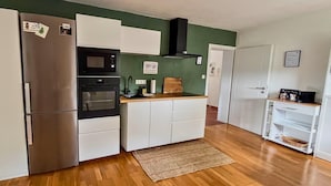 Una cocina compacta equipada con refrigerador, horno, microondas y una encimera de madera.