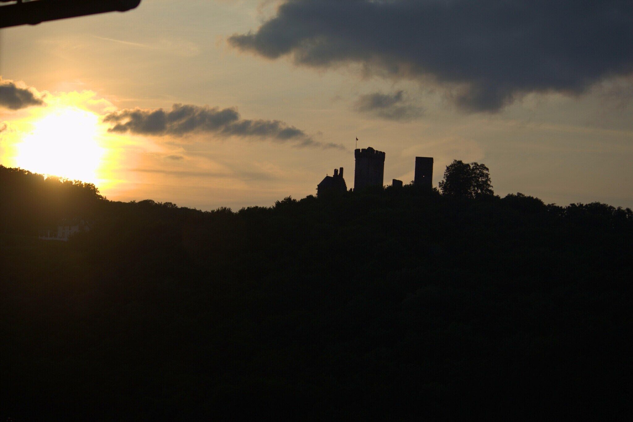 A silhouette of a castle against a sunset sky.