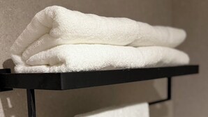 A black towel rack with two white towels hanging from it. - Star Hotel Pattaya (Pattaya)