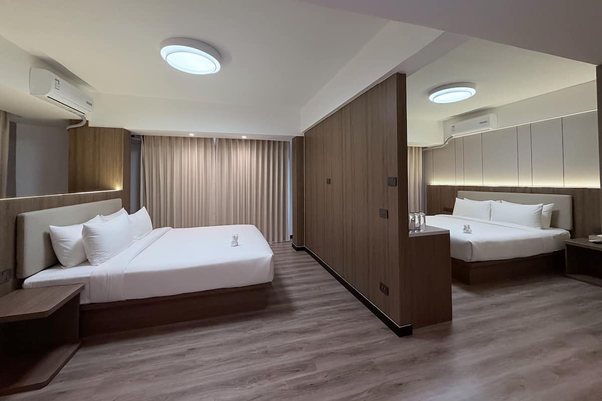 Una camera d'albergo moderna con un letto grande, un comodino, un armadio e uno specchio.