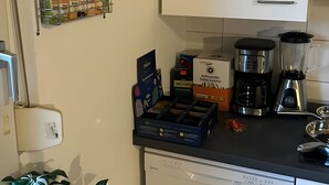 Eine Küche mit Kaffeemaschine, Mixer und Gewürzregal.