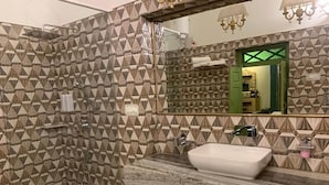 A bathroom with a geometric patterned wall, a marble sink, and a shower area. - Partap Mahal (Bikaner)