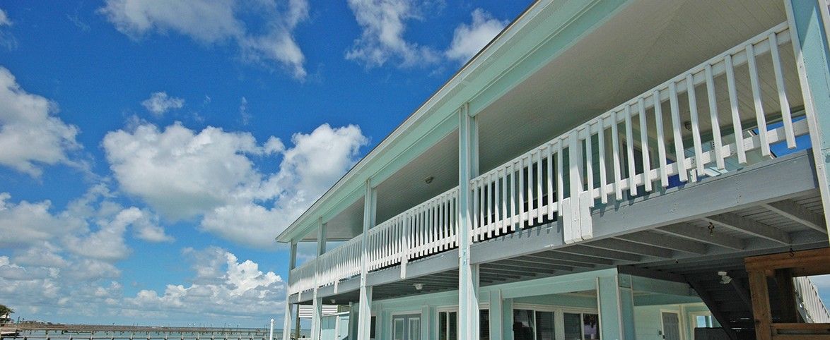 A waterfront property with a covered deck and outdoor seating area.