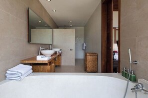 A modern bathroom with a large bathtub, a wooden vanity, a mirror, and a shower area. - Panacea Retreat 4 Bedroom - Kalya Residence (Koh Samui)