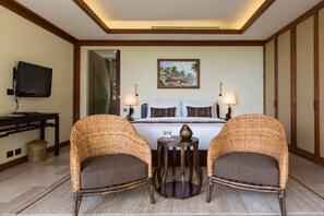 A hotel room with a bed, two wicker chairs, a small table, a TV, and a painting on the wall. - Panacea Retreat 4 Bedroom - Kalya Residence (Koh Samui)