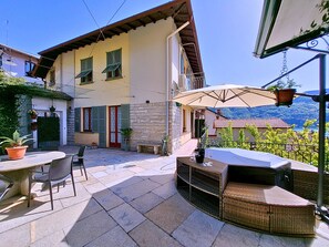 A patio with outdoor furniture, a stone floor, and a view of a mountain. - Jasmine House, Laglio, Lake Como (Laglio)