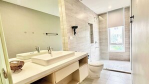 A modern bathroom with a dual sink vanity, a toilet, and a shower area. - LAGUNA Premier Hotel (Ho Chi Minh City)